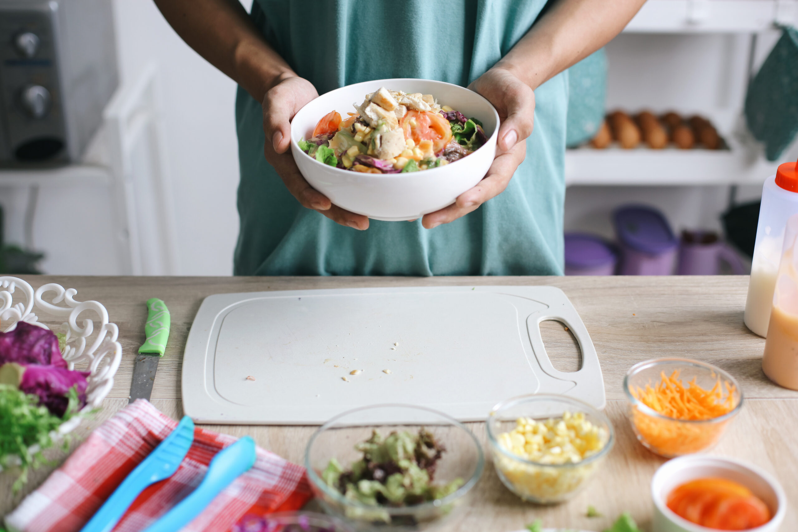 Mężczyzna z miską świeżych warzyw w kuchni