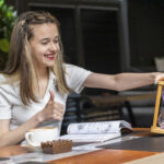 Uśmiechnięta dama trzymająca klepsydrę i gest kciuka w górę