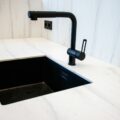 a kitchen sink with a black faucet over it