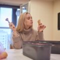 Uśmiechnięta dziewczyna jedząca lody ręce wkłada kulki lodów do rożka waflowego
