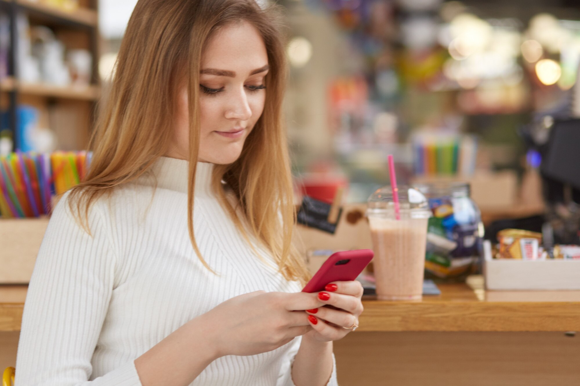Z ukosa strzał ładna kobieta trzyma telefon komórkowy