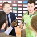 Młody sportowiec i trener na konferencji prasowej
